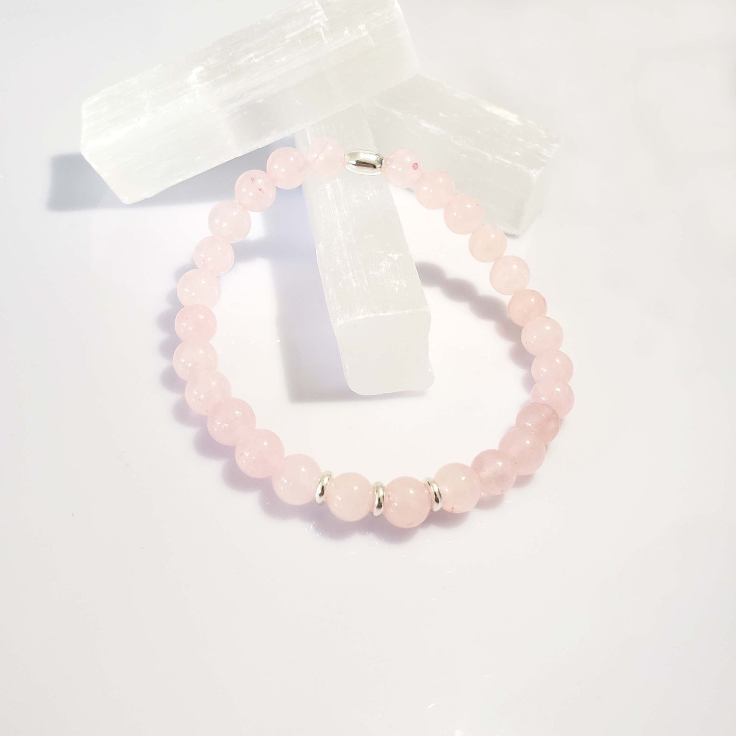 Pink rose quartz beaded bracelet on a white background